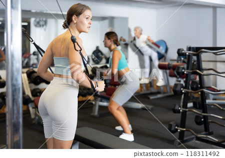 Young woman training with straps in gym Young woman training with straps in gym 118311492