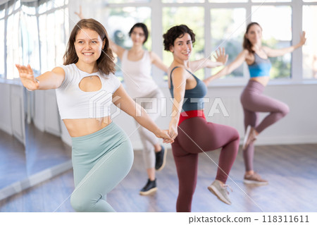 Cheerful girls learn to dance together modern and classical dances in dance studio 118311611
