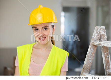 Woman worker posing in apartment being renovated Woman worker posing in apartment being renovated 118311662