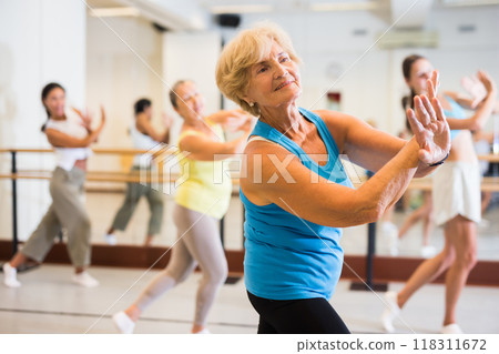 Portrait of an mature European woman enjoying energetic dancing in the studio 118311672