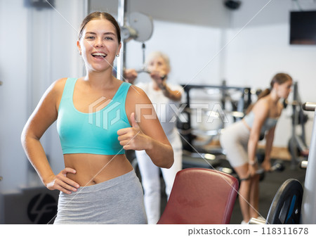 Portrait of slim woman smiling after work out in gym Portrait of slim woman smiling after work out in gym 118311678