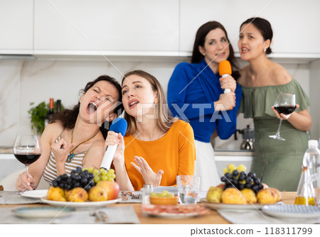 Group of women friends singing karaoke Group of women friends singing karaoke 118311799