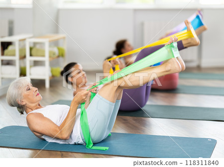 Group of people with working out with rubber bands in gym Group of people with working out with rubber bands in gym 118311840