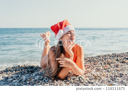 Woman in a Santa Hat Relaxing on a Pebble Beach Woman in a Santa Hat Relaxing on a Pebble Beach 118311875