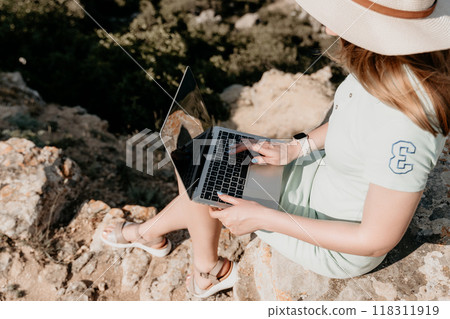 Woman Working on Laptop on Rocky Cliff 118311919