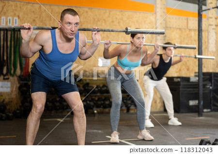 Concentrated athletic man performing exercises with barbell in gym Concentrated athletic man performing exercises with barbell in gym 118312043