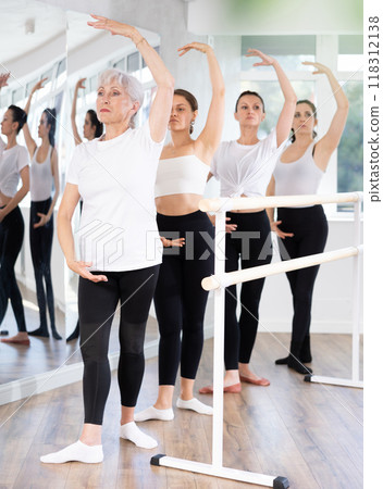 Senior female ballet dancer performing fourth position at training 118312138