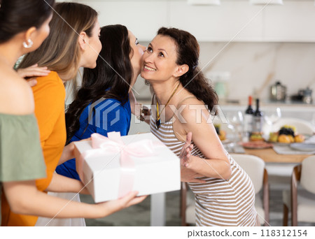 Group of women greeting each other and giving gift 118312154