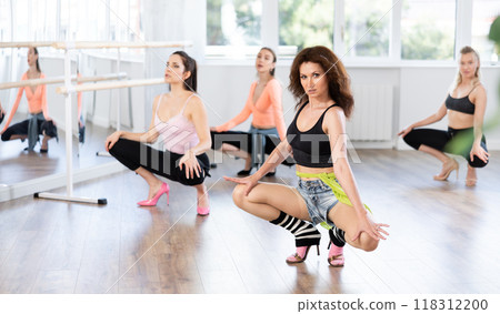 Group of women in high heels dances on floor 118312200