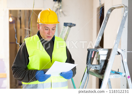 Male contractor looking at room and determining scope of building work 118312231