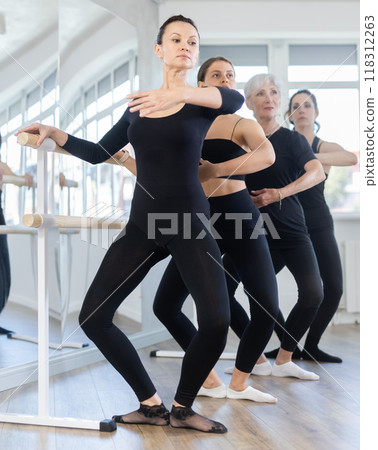 Group of dancers standing in grand plie ballet position in fitness room 118312263