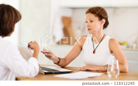 Female insurance agent tells woman the terms of property and life insurance 118312295