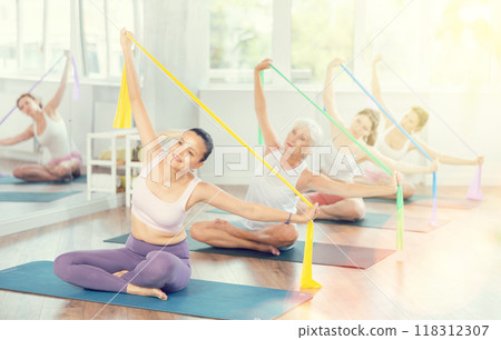 Young woman exercising with pilates band Young woman exercising with pilates band 118312307
