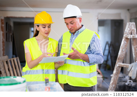 Woman engineer and man architect talking about documents Woman engineer and man architect talking about documents 118312524