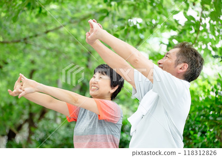 Senior couple stretching, fresh greenery 118312826