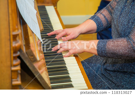 Female hands in gold jewelry with stones play keyboard piano. Female hands in gold jewelry with stones play keyboard piano. 118313027