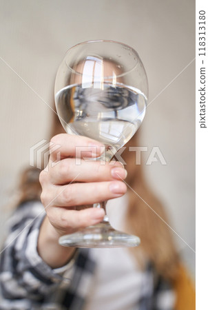 Close-up of woman holding a glass of water with outstretched hand capturing 118313180