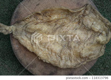 Detail of Fish Maw Soup or Dried Fish Stomach on Old wooden cutting board. Detail of Fish Maw Soup or Dried Fish Stomach on Old wooden cutting board. 118313796