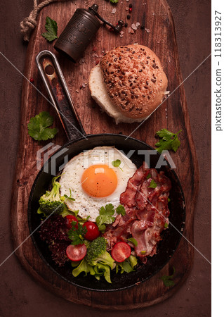fried egg, with bacon and vegetables, in a cast-iron frying pan, top view, homemade breakfast, fried egg, with bacon and vegetables, in a cast-iron frying pan, top view, homemade breakfast, 118313927