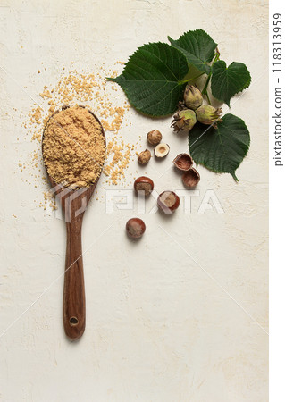 wooden spoon with hazelnut flour, top view, no people, on a white table 118313959