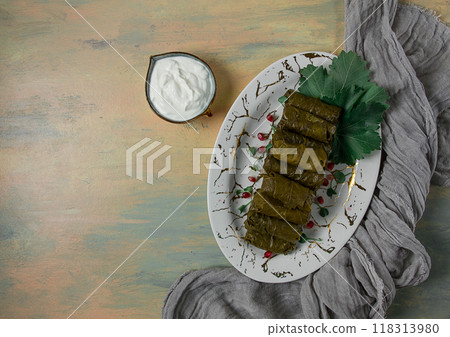 Dolma, cabbage rolls in grape leaves, Traditional Armenian dish, with white sauce, top view, close-up, selective focus, Dolma, cabbage rolls in grape leaves, Traditional Armenian dish, with white sauce, top view, close-up, selective focus, 118313980