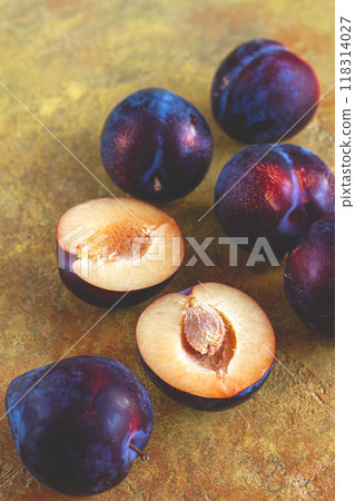 plums scattered on the table, fresh, top view, yellow-orange background, no people, 118314027