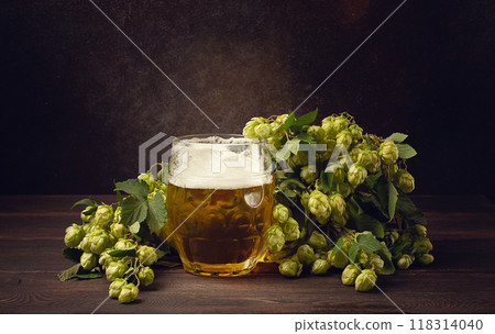 A mug of beer , on a wooden table, with a branch of fresh hops, rustic , no people, A mug of beer , on a wooden table, with a branch of fresh hops, rustic , no people, 118314040