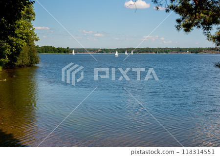 Sailboats on water in Sweden. Children sailing small sailboats (catamarans) on a lake. Sailboats on water in Sweden. Children sailing small sailboats (catamarans) on a lake. 118314551