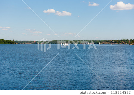 Sailboats on water in Sweden. Children sailing small sailboats (catamarans) on a lake. 118314552