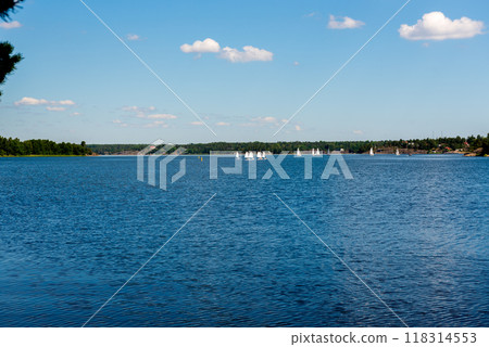 Sailboats on water in Sweden. Children sailing small sailboats (catamarans) on a lake. Sailboats on water in Sweden. Children sailing small sailboats (catamarans) on a lake. 118314553