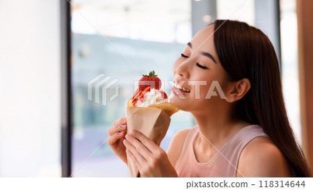 Woman eating strawberry crepe Woman eating strawberry crepe 118314644