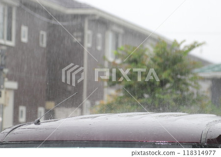 Sudden downpour: Raindrops splashing on a car 118314977