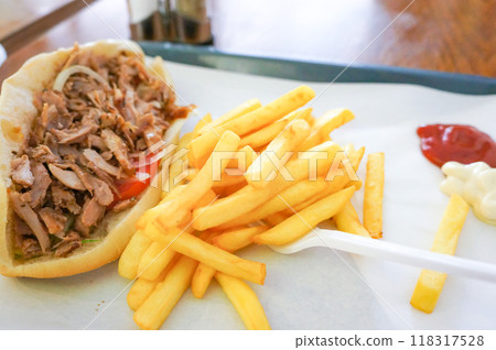 A sandwich filled with fries and lots of meat 118317528
