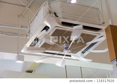 Roatating fan flap attached to air conditioner unit to disperse cold air evenly in room. Motion blur of fan intended. 118317620