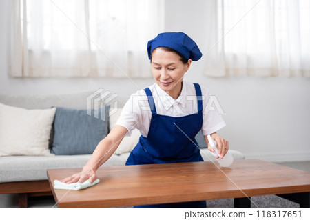 Senior housekeeper in a white polo shirt with a blue apron (male and female, married couple, independent, retired) 118317651