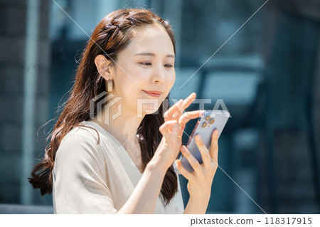 A woman watching a smartphone A woman watching a smartphone 118317915