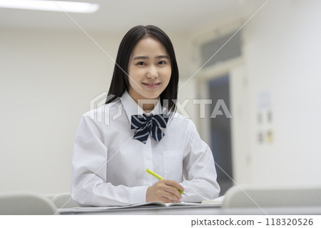 A portrait of a high school girl studying and smiling at the camera. Photo courtesy of Ariake College of Education and Arts. 118320526