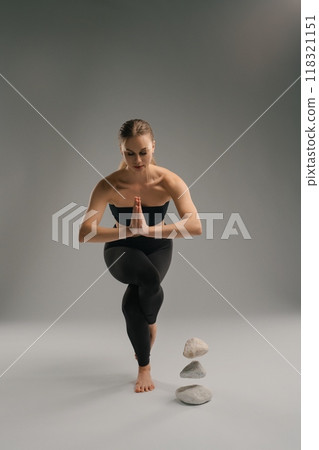 Yoga practitioner demonstrating balance and focus in a tranquil studio setting 118321151