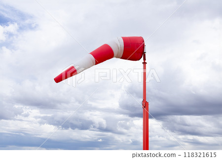 Red and white weather vane and dramatic cloudy sky. Red and white weather vane and dramatic cloudy sky. 118321615