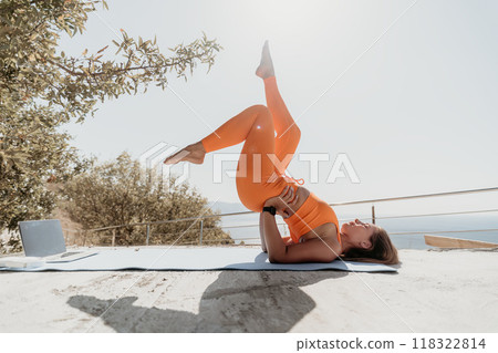 Woman in Orange Yoga Outfit Performing a Backbend Pose Woman in Orange Yoga Outfit Performing a Backbend Pose 118322814