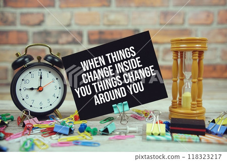When Things Change Inside You Things Change Around You? text on paper card with alarm clock and stationary on wooden background When Things Change Inside You Things Change Around You? text on paper card with alarm clock and stationary on wooden background 118323217