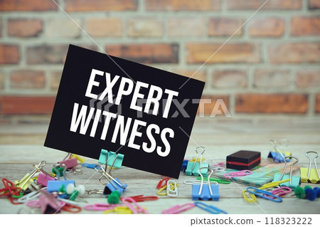 Expert Witness text on paper card with stationary on wooden background 118323222