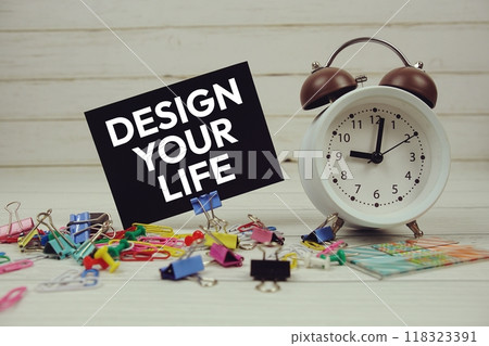 Design Your Life text on paper card with alarm clock and stationary on wooden background 118323391