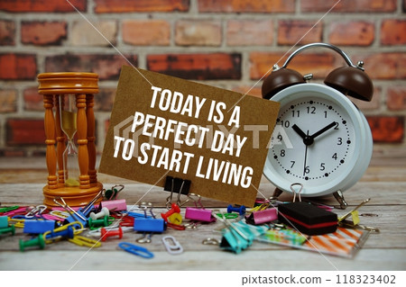 Today is a Perfect Day to Start Living Your Dreams text on paper card with alarm clock and stationary on wooden background 118323402