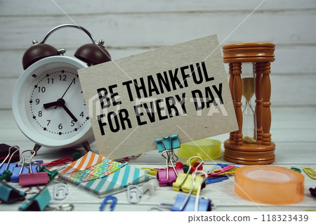 Be Thankful for Every Day text on paper card with alarm clock and stationary on wooden background 118323439