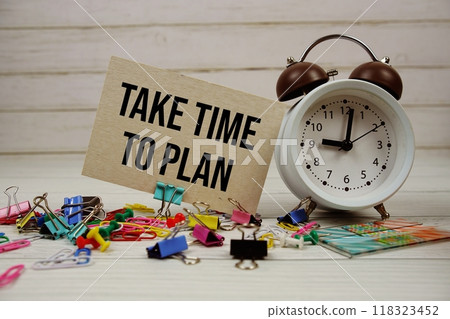 Take Time To Plan text on paper card with alarm clock and stationary on wooden background 118323452