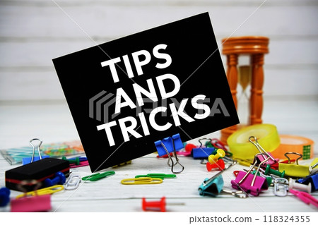 Tips And Tricks text on paper card with stationary on wooden background 118324355