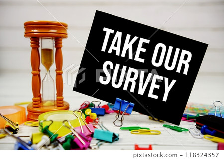 Take Our Survey text on paper card with alarm clock and stationary on wooden background Take Our Survey text on paper card with alarm clock and stationary on wooden background 118324357