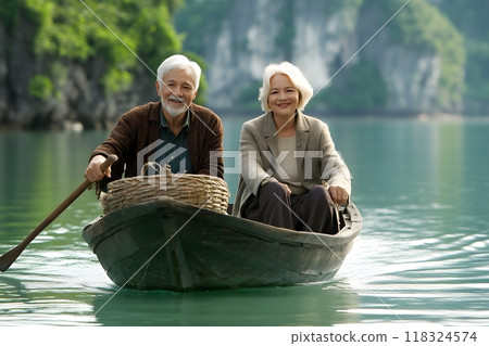 Portrait of happy senior couple sitting in a boat on a calm lake, senior travel conce 118324574