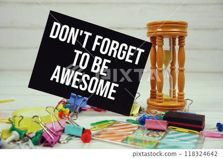 Don't Forget To Be Awesome text on paper card with hourglass and stationary on wooden background Don't Forget To Be Awesome text on paper card with hourglass and stationary on wooden background 118324642